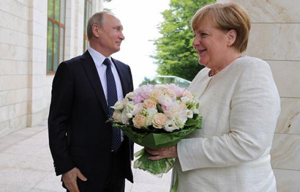 Báo Đức chỉ trích Tổng thống Nga Putin vì tặng hoa Thủ tướng Merkel - 0