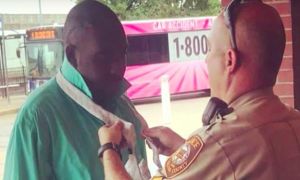  Người cảnh sát dạy chàng thanh niên da màu thắt cà vạt ngay sau cuộc đụng độ