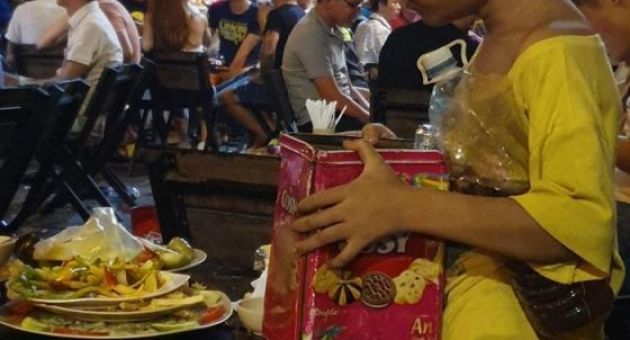Chạnh lòng bức ảnh cậu bé lem luốc nhặt thức ăn thừa để qua cơn đói: 'Cùng là...